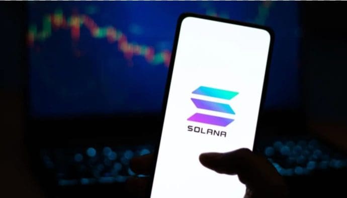 Solana-Logo auf einem Telefon mit einem Aktienchart im Hintergrund