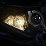 Ein Bild von Bitcoin-Münzen in einer Wochenendtasche, die oft bei Raubüberfällen benutzt wird, und eine Lupe, um die Sache genauer zu betrachten.