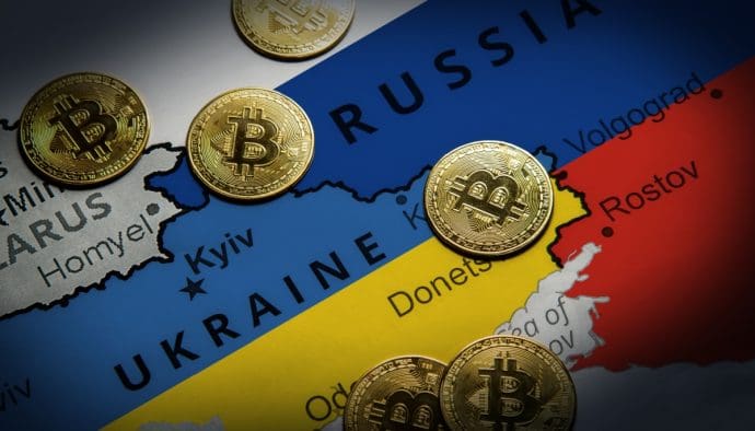 Een afbeelding van een landkaart met Rusland en Oekraïne, met daartussen bitcoinmunten verspreid Ein Bild von einer Landkarte mit Russland und der Ukraine, dazwischen sind Bitcoin-Münzen verteilt.
