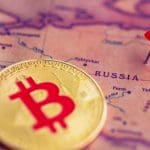 Eine Abbildung einer Bitcoin (BTC)-Münze neben einer Stecknadel auf dem Land Russland