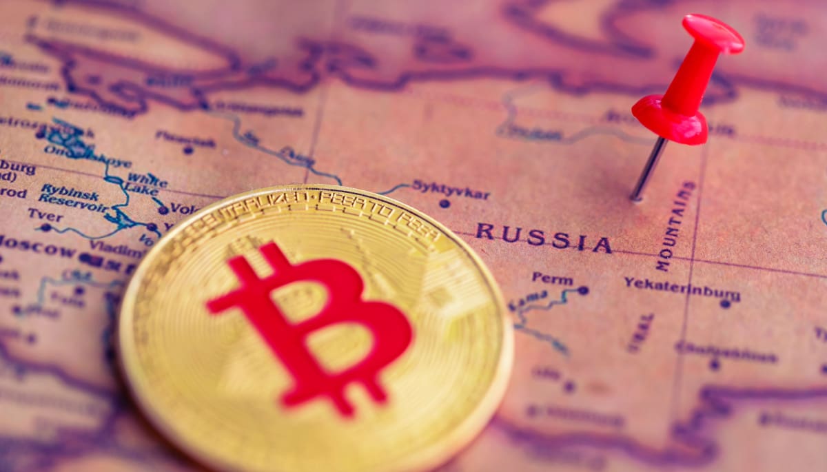 Eine Abbildung einer Bitcoin (BTC)-Münze neben einer Stecknadel auf dem Land Russland