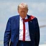 Ein Bild des amerikanischen Präsidenten Donald Trump, der von einem Hubschrauber weg in Richtung Kamera läuft.