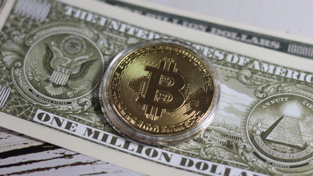 Ein Bild von einer Bitcoin-Münze auf einem Dollarschein