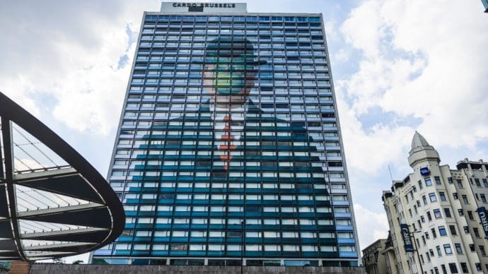 Een afbeelding van ‚the son of man‘ van rene margritte op een gebouw in brussel Der mysteriöse Typ hinter einem Krypto-Betrug in Höhe von 12 Milliarden Euro
