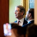 Der amerikanische Finanzminister Scott Bessent, der im Weißen Haus durch einen Spalt zu sehen ist, wie er mit JD Vance redet.