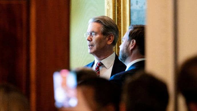 Der amerikanische Finanzminister Scott Bessent, der im Weißen Haus durch einen Spalt zu sehen ist, wie er mit JD Vance redet.