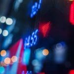 Ein Bild von einem Schild mit Aktien und roten Zahlen drauf.