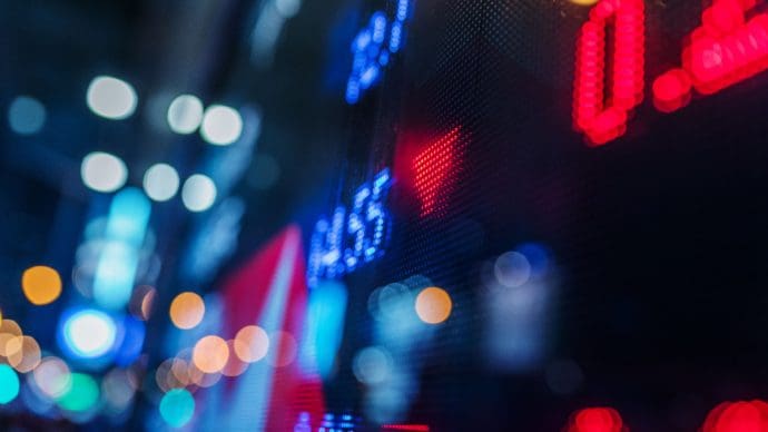 Ein Bild von einem Schild mit Aktien und roten Zahlen drauf.